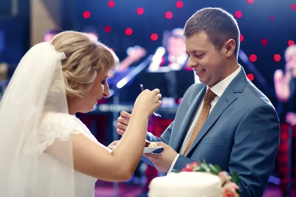 Feliz bonito recém-casados gosto bolo no restaurante — Fotografia de Stock