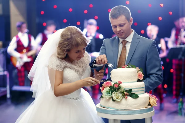Glada vackra nygifta smaka kaka i restaurangen — Stockfoto