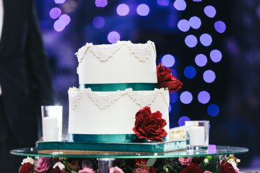 Beyaz düğün pastası ve cam masa mum 