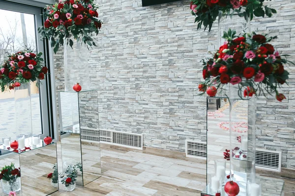White brick wall decorated with red bouquets and glass boxes in — Stock Photo, Image