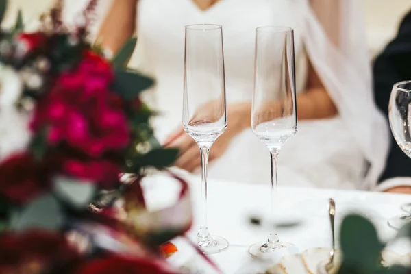 Des verres à vin chamagne vides se tiennent devant les jeunes mariés — Photo