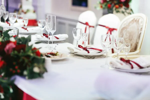 Weißer Hochzeitstisch mit roten Bändern dekoriert — Stockfoto