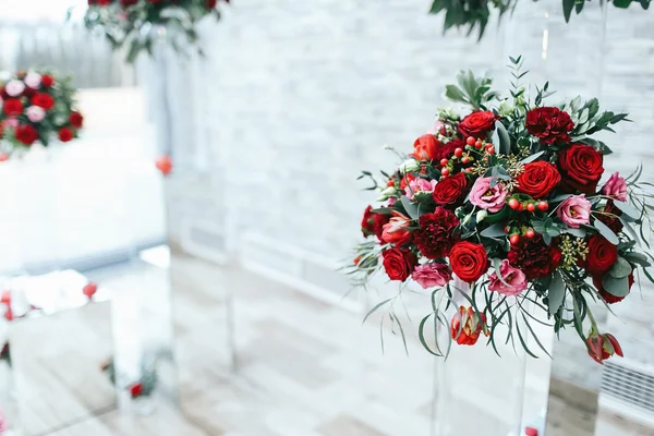 Buquê vermelho de rosas, peônias e ranúnculos fica no vidro — Fotografia de Stock