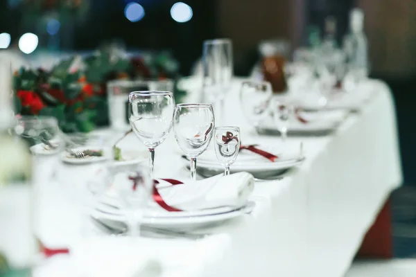 Bruiloft tafel set met witte servetten en rode linten — Stockfoto