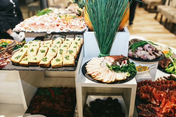 Different kinds of meat lay on a black dishes — Stock Photo, Image