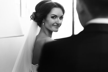 Gelin Damat'ın omuz üzerinden bir gülümseme ile görünüyor 