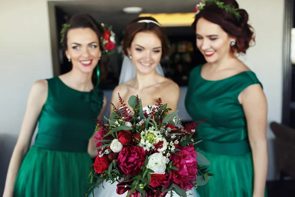 Bride surrounded by braidsmaids reach out her hand with bouquet — Stock Photo, Image