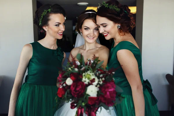 Bride reach out a bouquet while making fun with bridesmaids — Stock Photo, Image