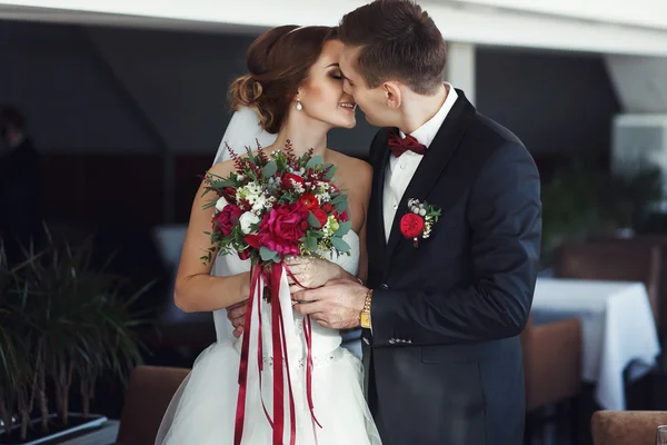 Verloofde van bruid taille knuffels en kusjes van haar — Stockfoto