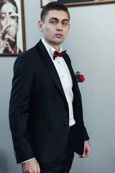 Confident young man in tuxedo with bow tie posing at camera — Stock Photo, Image