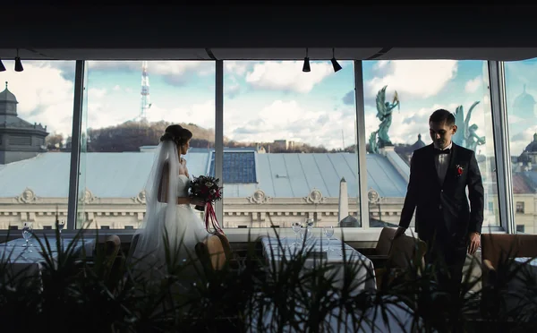 Braut und Verlobter spazieren mit Gr zwischen leeren Tischen im Restaurant — Stockfoto