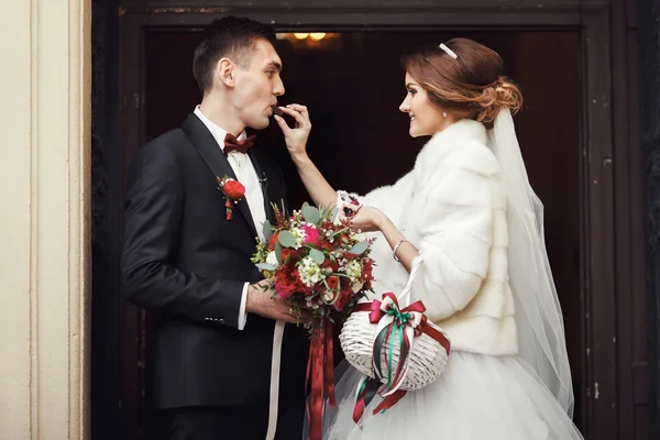 Sposa dare un fidanzato un cioccolato nella parte anteriore della doo della chiesa — Foto Stock