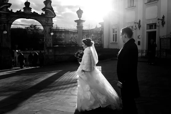 Невеста идет к церковным воротам в лучах солнечного света — стоковое фото