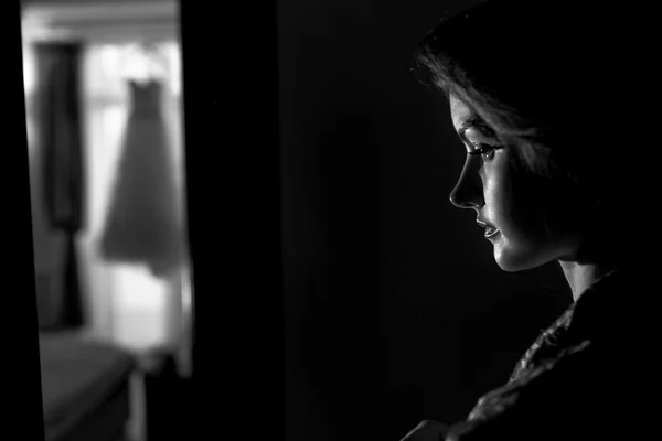 Bride stands thoughtfully in the dark room — Stock Photo, Image