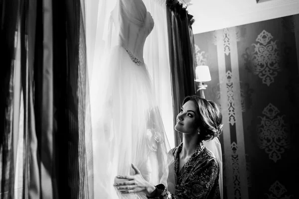 Наречена тримає свою весільну сукню — стокове фото