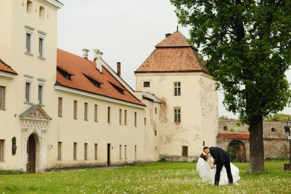 Yeni evliler öpücük eski manastır önünde — Stok fotoğraf