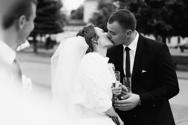 Recém-casados beijo de paixão com champanhe — Fotografia de Stock