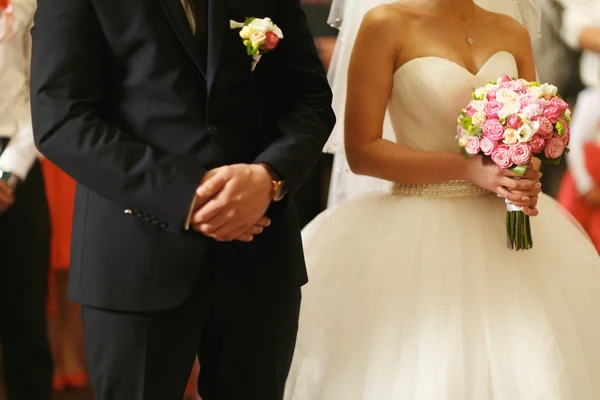 Couple stands together during the ceremony in the church — Stock Photo, Image