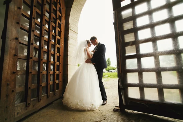 Schöne Braut und Bräutigam stehen im Eingang zu einem alten Fortre — Stockfoto