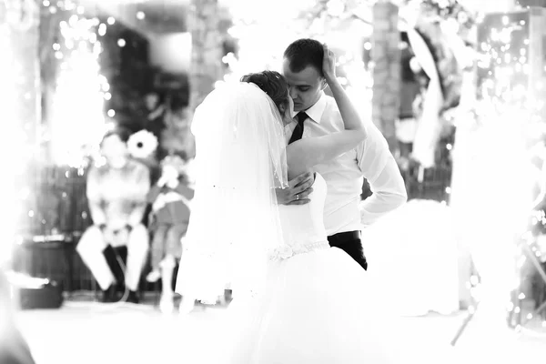 Ein zarter Kuss des Brautpaares im Lichterglanz des Feuerwerks — Stockfoto