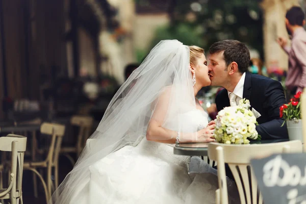 Bride and groom kiss at the table — Φωτογραφία Αρχείου