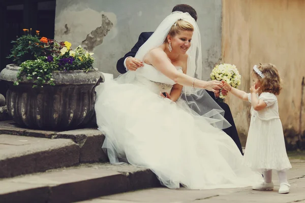 Bride gives a bouquet to a little girl — Stock Photo, Image