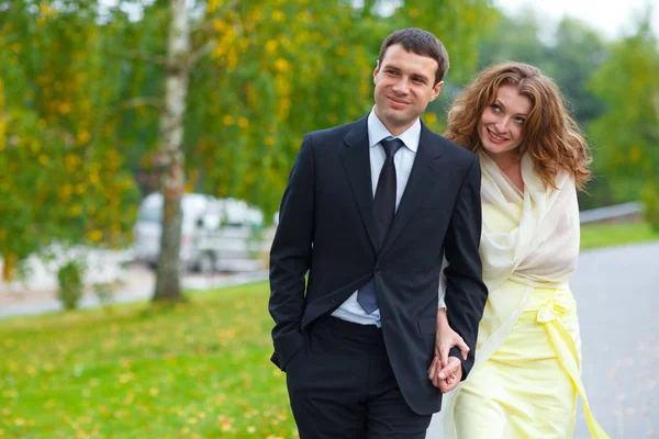 Mujer muecas sosteniendo la mano del hombre y caminando alrededor de un parque — Foto de Stock