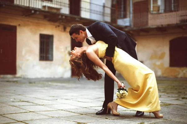 Brudgummen har på lutningen en brud i gul klänning — Stockfoto