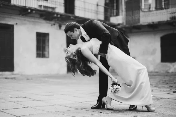 Groom segura uma noiva na inclinação em algum lugar da cidade — Fotografia de Stock