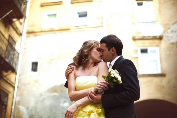 Bräutigam küsst eine Braut, die ihre Schultern hält — Stockfoto