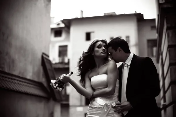Sposo baci sposa spalla mentre lei guarda nella fotocamera — Foto Stock