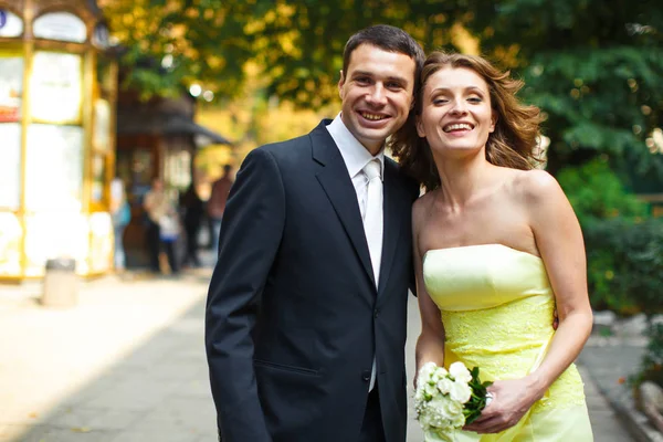 Recém-casados parecem felizes de pé no parque — Fotografia de Stock