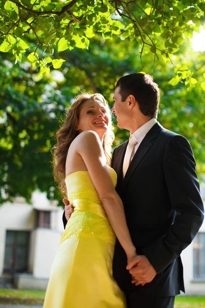 Sol resalta mujer en vestido amarillo mientras abraza a un hombre — Foto de Stock