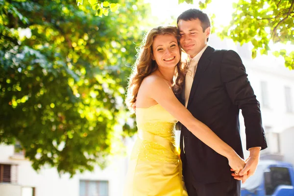 Düğün çift gülümsüyor yeşil ağaçların altında — Stok fotoğraf