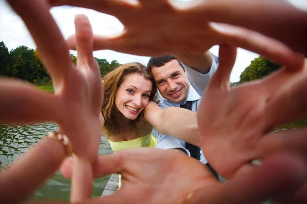 Homme et femme sourient en levant la main vers la caméra — Photo
