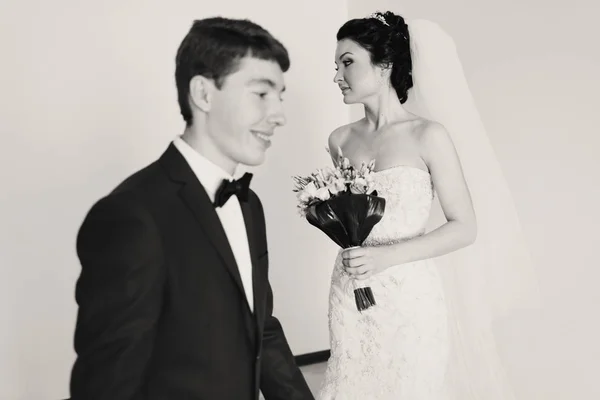 Groom crosses a room while bride stands thoughtfully on the back — Stock Photo, Image