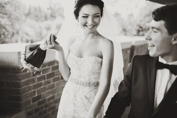 Γαμπρός και νύφη γέλιο ενώ απέχει με τα πόδια κρατώντας στα χέρια τους μαζί — Φωτογραφία Αρχείου
