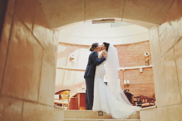 Uma vista sobre o casal beijando em pé no túnel do corredor — Fotografia de Stock