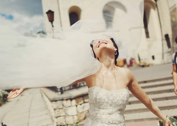 Der Schleier der Braut fliegt auf, wenn sie durch eine Stadt geht — Stockfoto