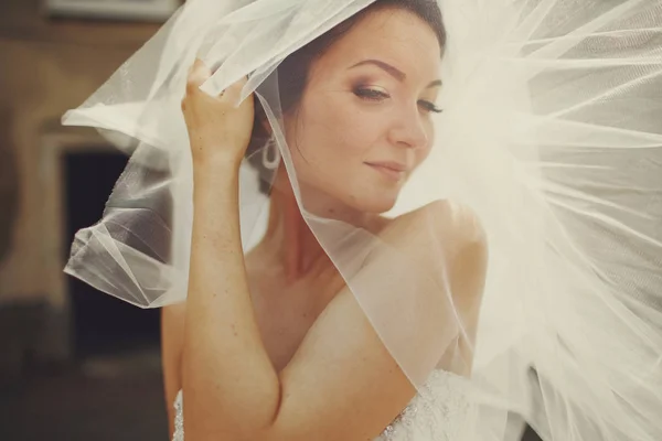 Nevěsta vypadá zamyšleně, zakryla tvář za závojem — Stock fotografie