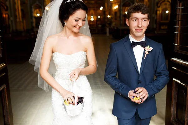 Braut und Bräutigam tragen Süßigkeiten für ihre Gäste — Stockfoto