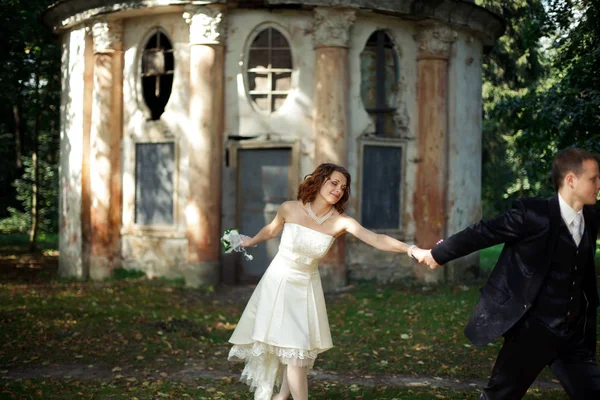 Sposo conduce una sposa che le tiene la mano — Foto Stock