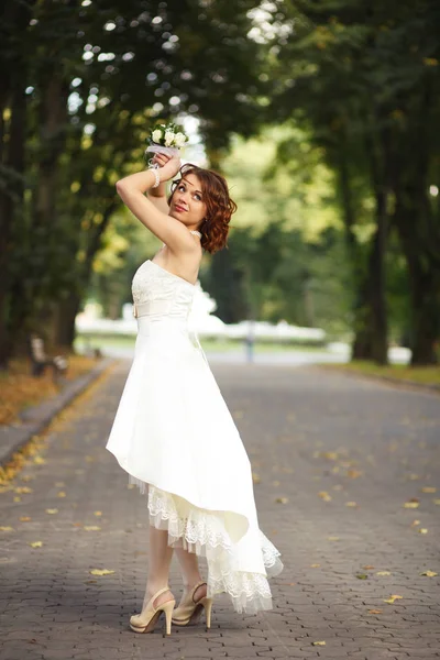 Невеста позирует на дорожке в парке — стоковое фото