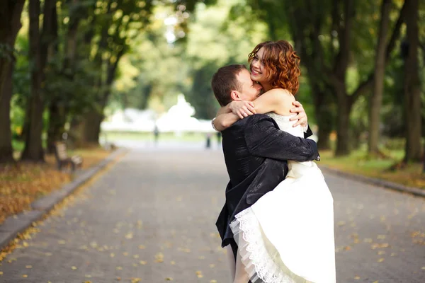 Marié plie une mariée dans ses bras — Photo