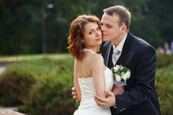 Marié tient une mariée dans un parc — Photo