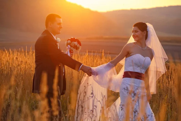 幸せな結婚式のカップルに輝く夕日 — ストック写真