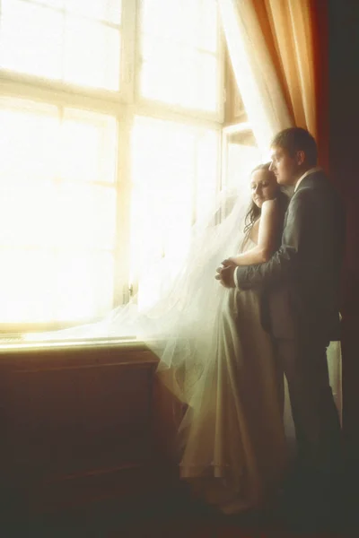 Couple daydreams in the sunlight while they look out of the wind — Stock Photo, Image