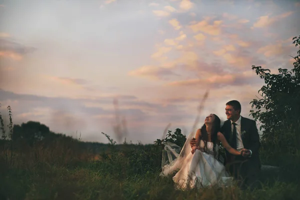 Recém-casados rir céu wathcing no campo — Fotografia de Stock