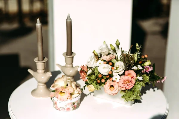 Grijze kaarsen en kleurige bloemen — Stockfoto