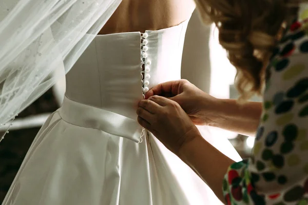 Mujer está ayudando a vestir a la novia — Foto de Stock